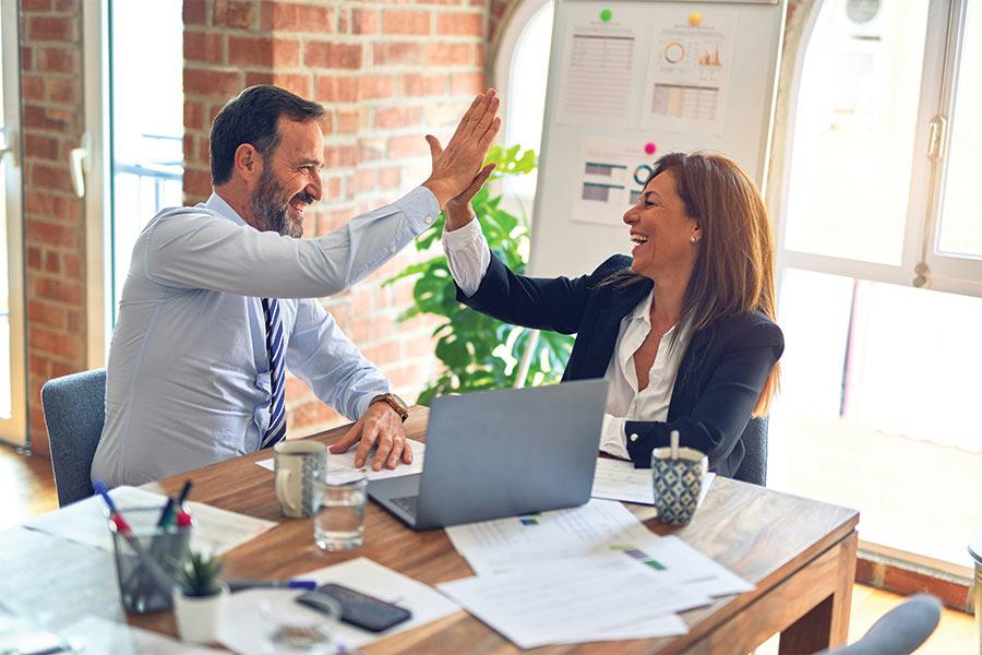 crm systems blog image showing a small business team high fiving Photo by krakenimages on Unsplash